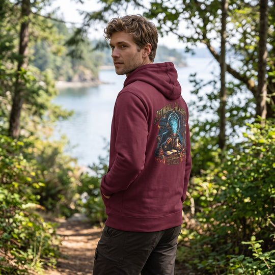 Port Townsend Aetheric Alchemy hoodie worn outdoors, model in casual shirt style amidst natural greenery and water backdrop