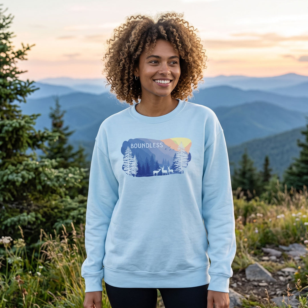 Adult model Zara wearing Boundless Ridge fleece sweatshirt in a natural outdoor setting with greenery, sunlight, and blurred foliage