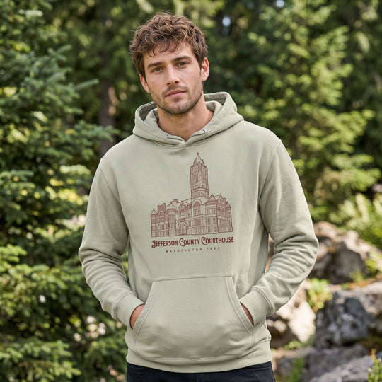 Effortless style of a model wearing Jefferson County Courthouse hoodie outdoors in bright sunlight with organic background elements.