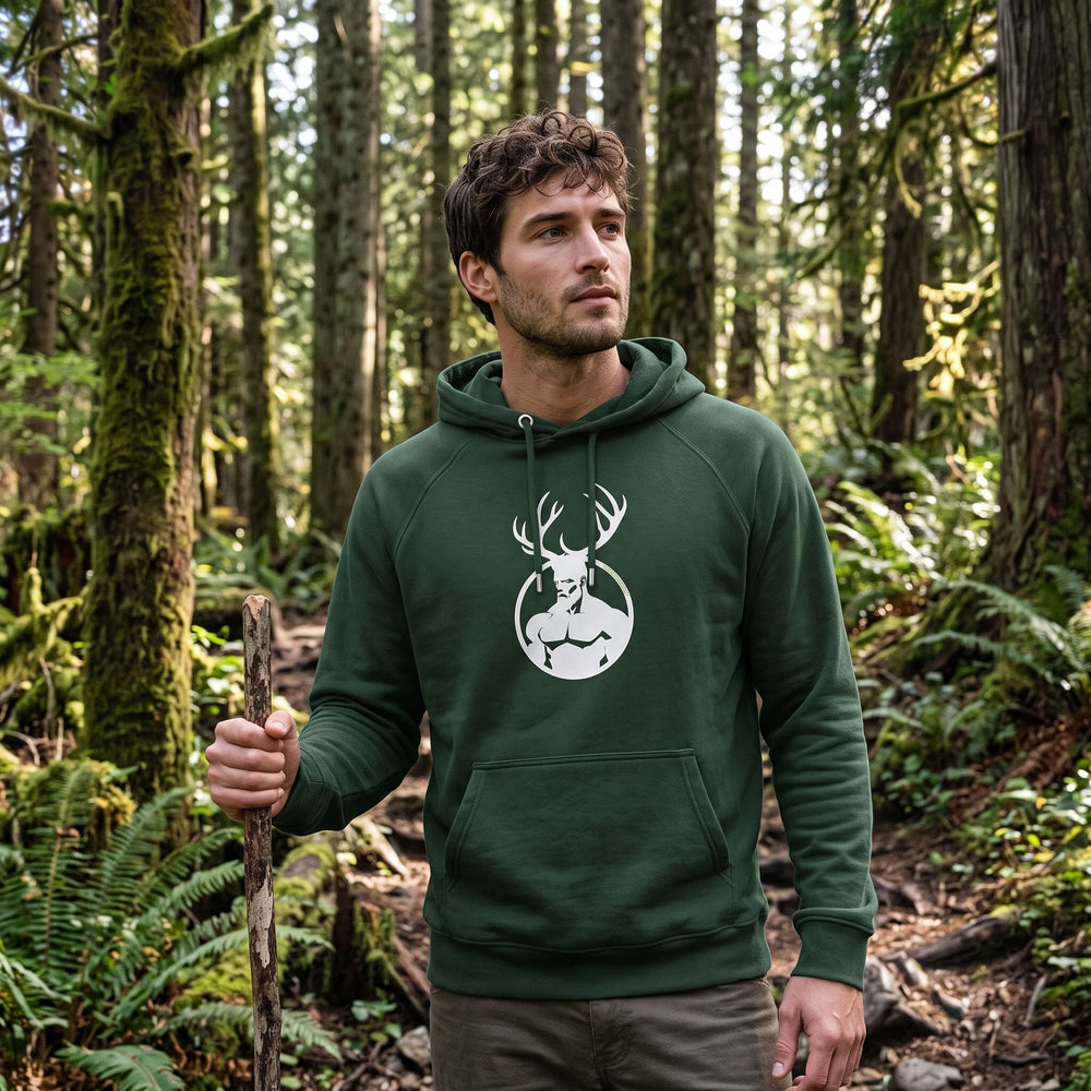 Men's organic cotton hooded sweatshirt featuring Cernunnos primal design, outdoors with greenery and natural light, relaxed lifestyle style.