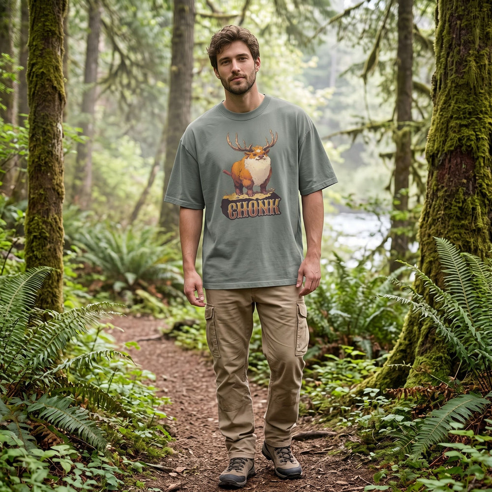 Casual model wearing the Chonk of the Forest oversized faded T-shirt outdoors with greenery, in natural daylight showcasing a relaxed, wilderness-inspired style.