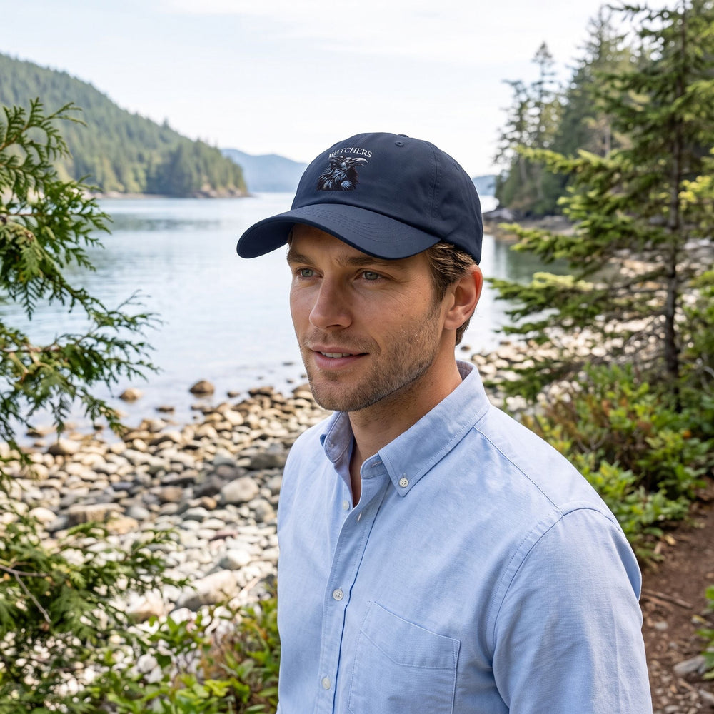 Adult male model wearing Crow Watchers Dad Hat outdoors with natural greenery and bright sunlight, showcasing casual style and adjustable strap.