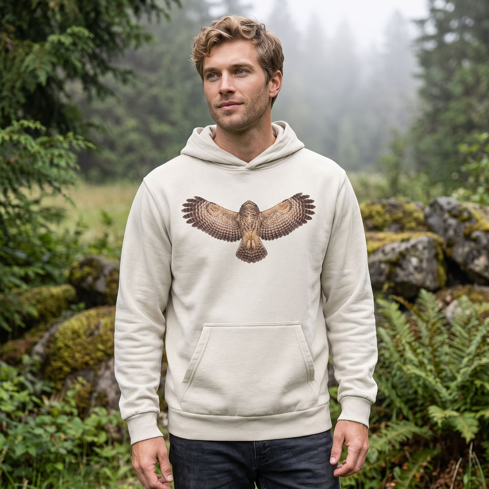 Model showcasing owl in flight illustration hoodie outdoors with lush greenery, emphasizing detailed design and casual style.