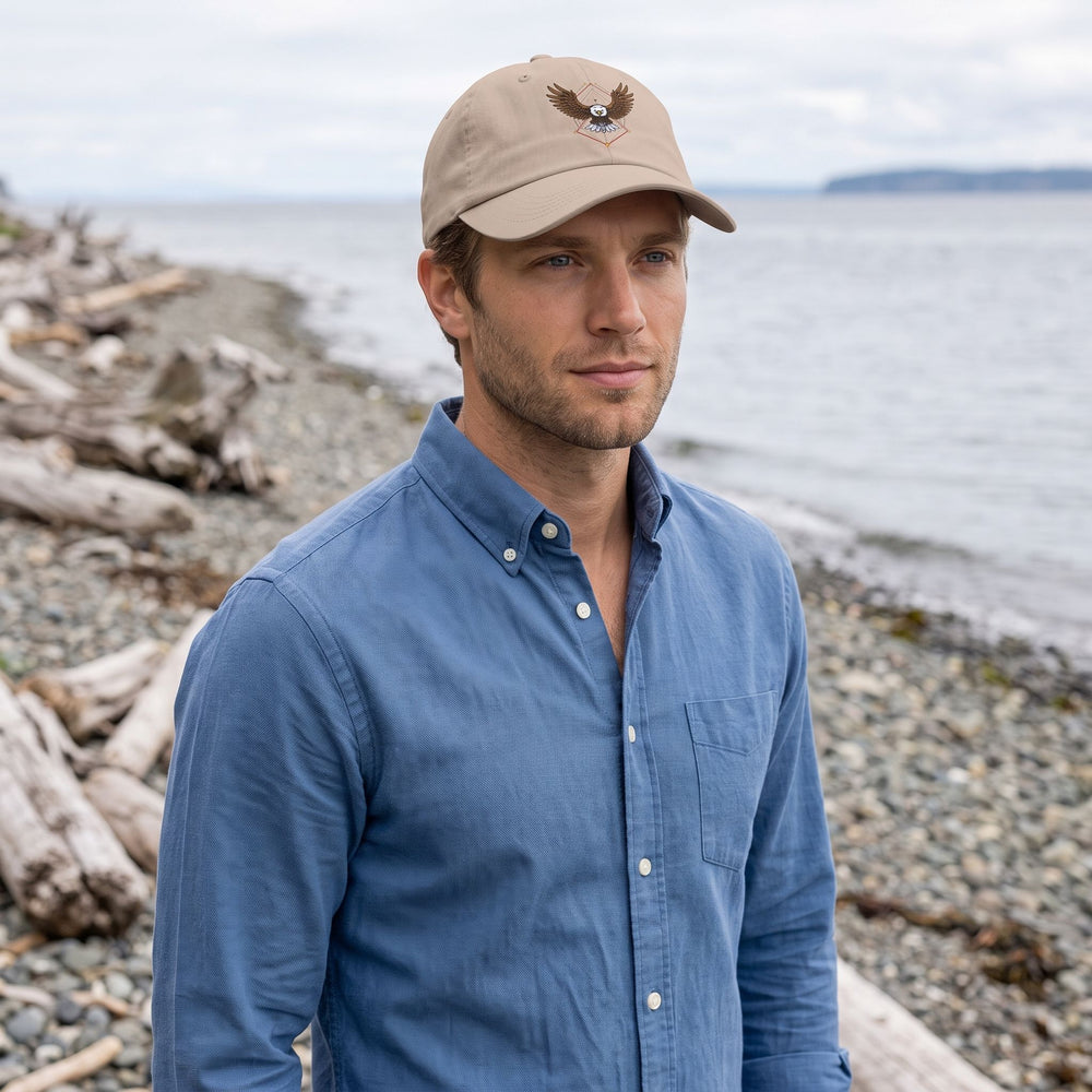 Men's low-profile eagle geometry dad hat made of chino twill worn outdoors, featuring a curved visor and adjustable strap in a natural setting.