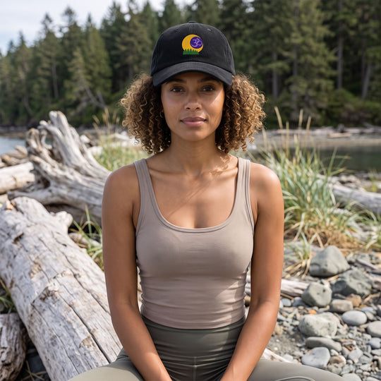 Outdoor scene with Zara modeling the Forest Om Corduroy Meditation Cap amidst greenery, highlighting its natural style and celestial embroidery.