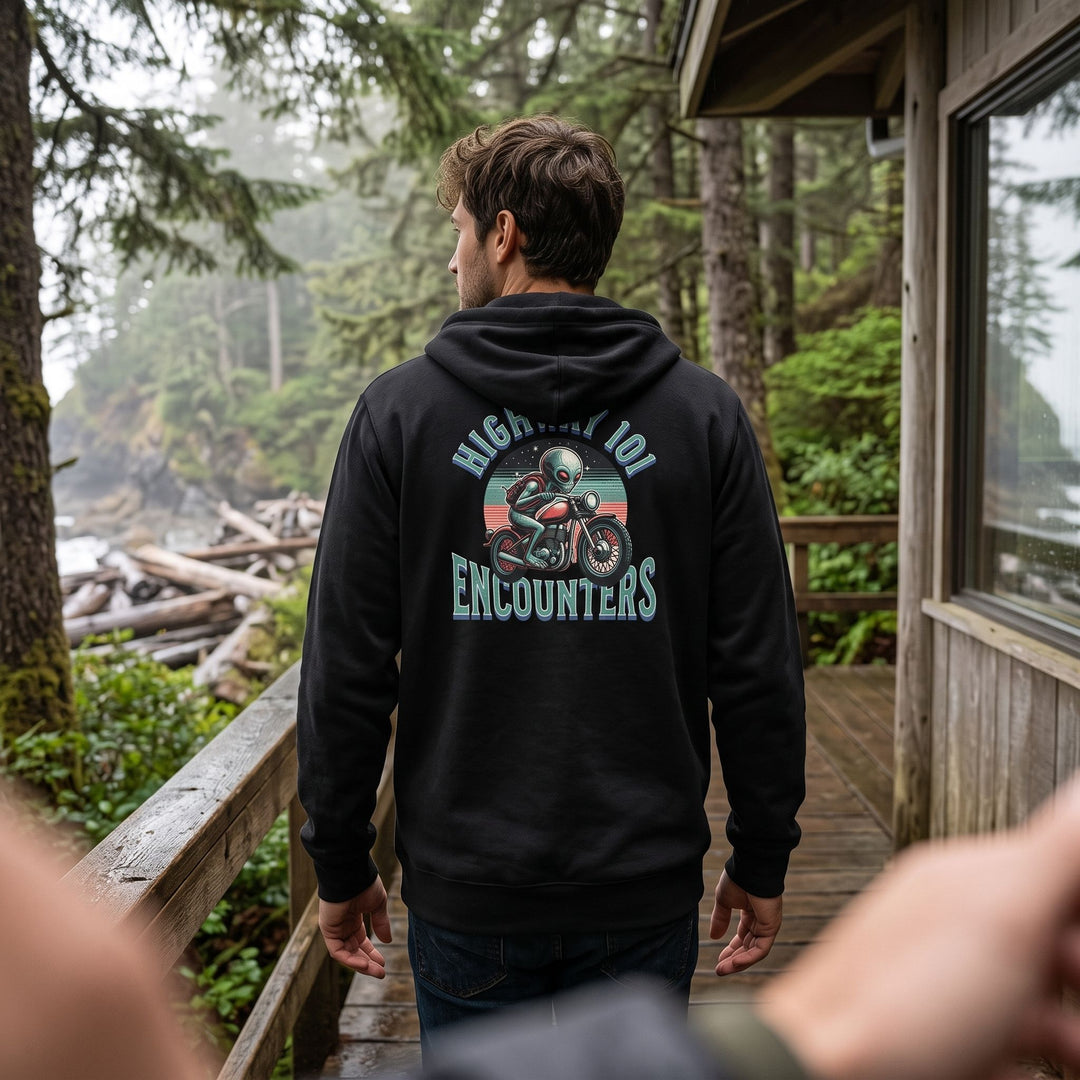 Casual scene featuring Alex wearing Highway 101 Encounters Zip Hoodie in a cozy living room with warm natural light.