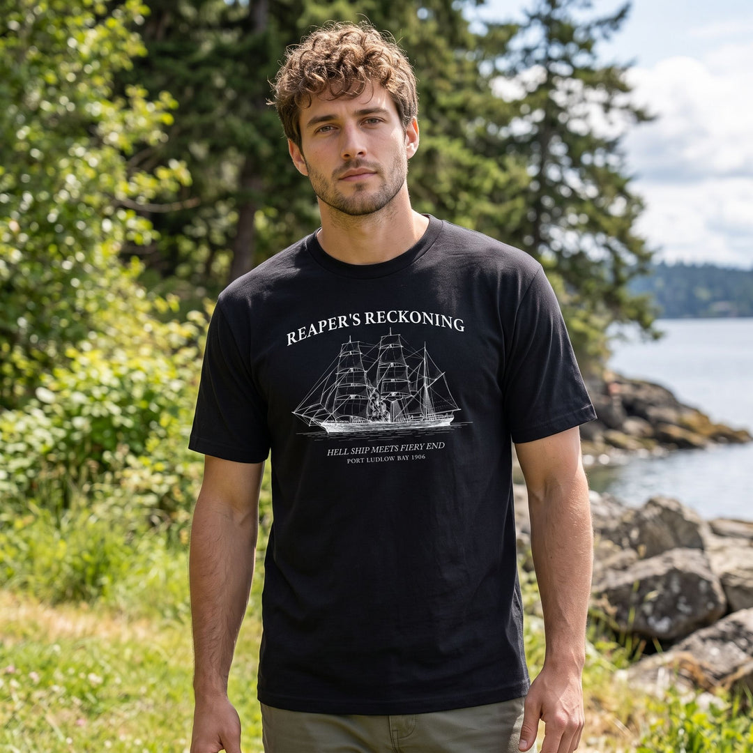Model wearing maritime-themed T-shirt in outdoor setting with natural daylight and blurred foliage background.