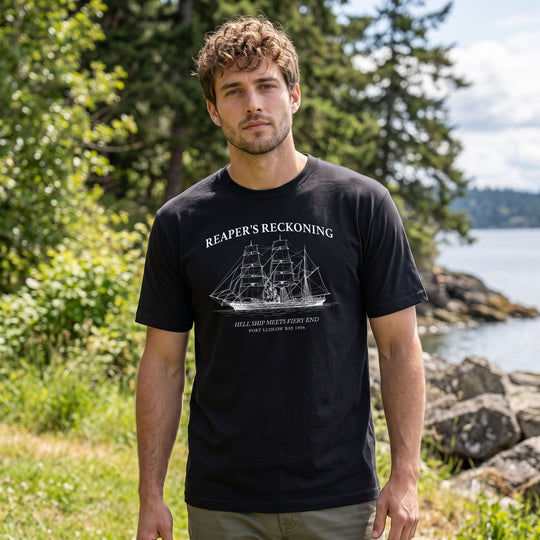 Model wearing maritime-themed T-shirt in outdoor setting with natural daylight and blurred foliage background.