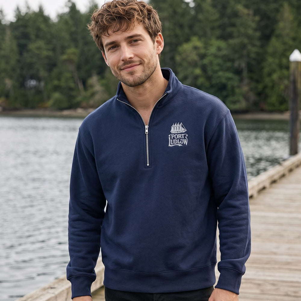 Casual male model in a relaxed outdoor scene showcasing the navy Port Ludlow fleece pullover with vintage logo.