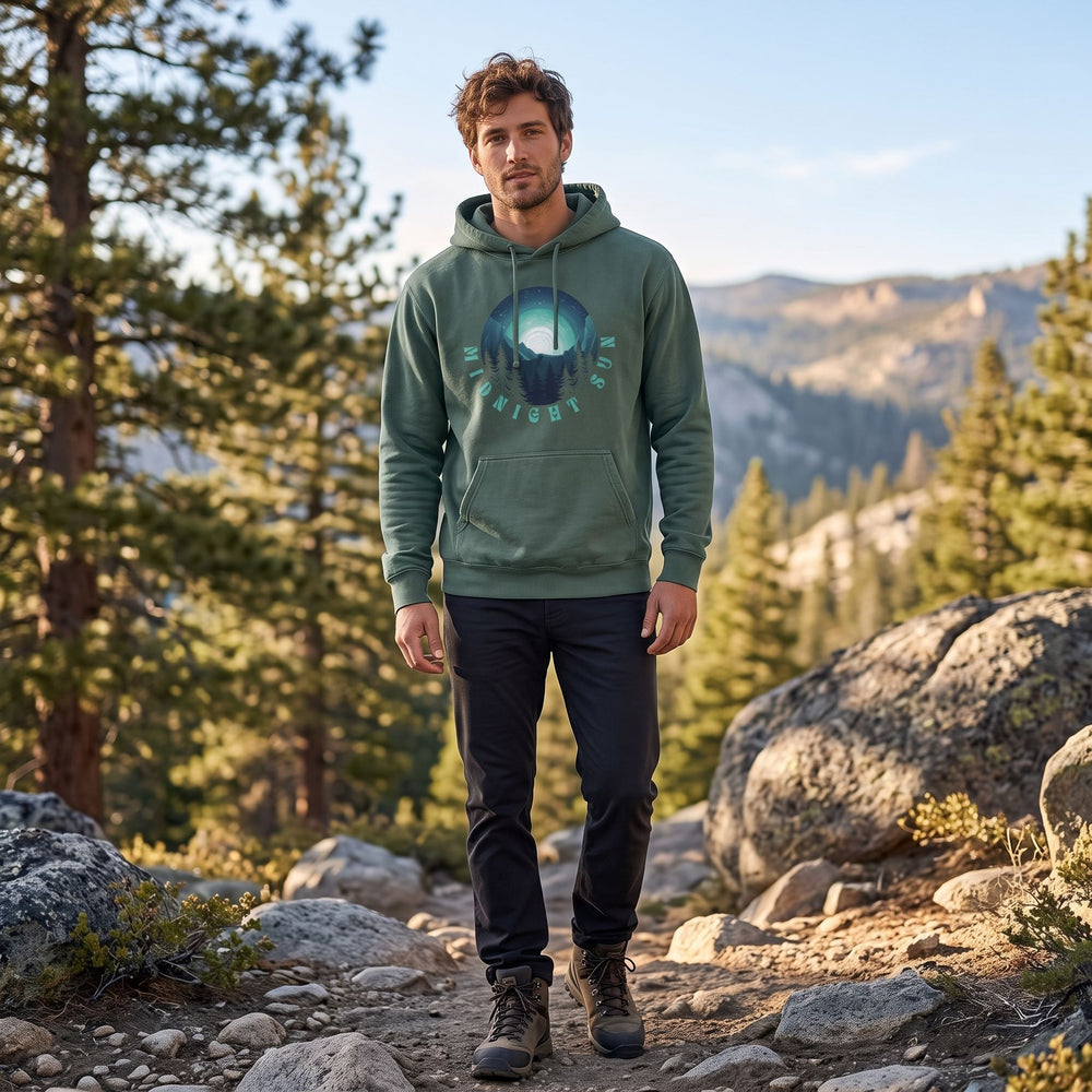 Relaxed-fit Midnight Sun hoodie with celestial graphic in an outdoor setting with greenery and natural daylight, model styled casually.