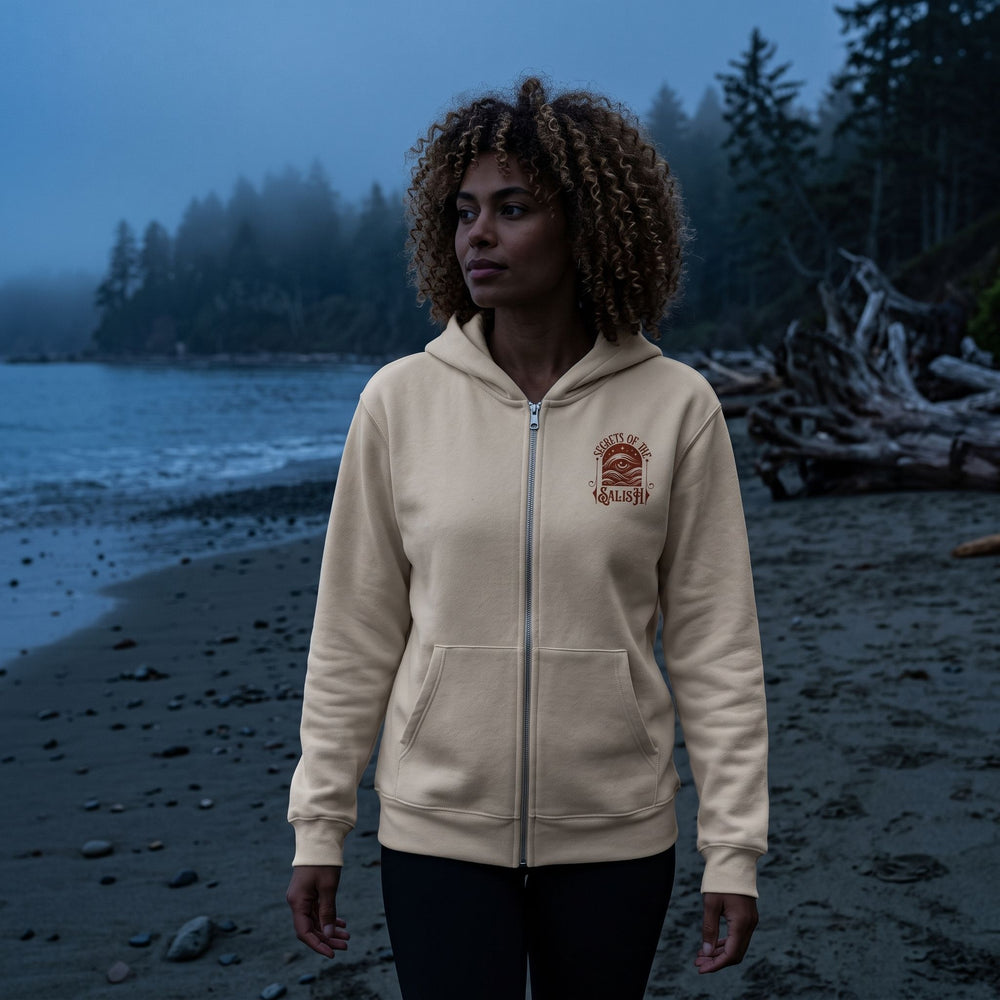 Adult model wearing the Secrets of the Salish heavyweight full-zip hoodie in a dark moody setting, emphasizing ocean-inspired mysticism.