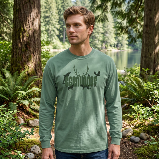 Casual outdoor scene showing male model in Cernunnos shirt with antler graphic and natural greenery backdrop.