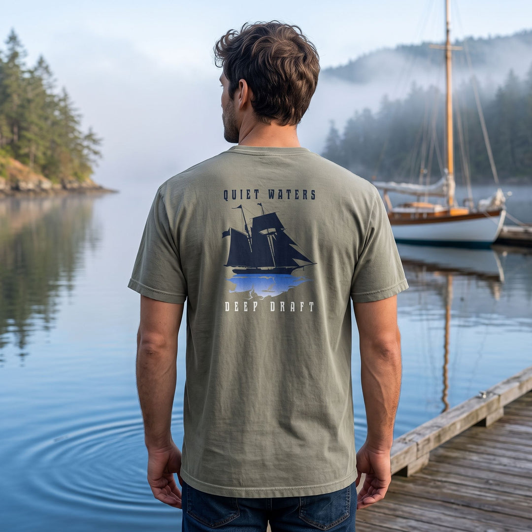 Model Alex outdoors in natural light wearing the coastal-inspired heavyweight garment-dyed t-shirt with relaxed fit, surrounded by blurred foliage and water.