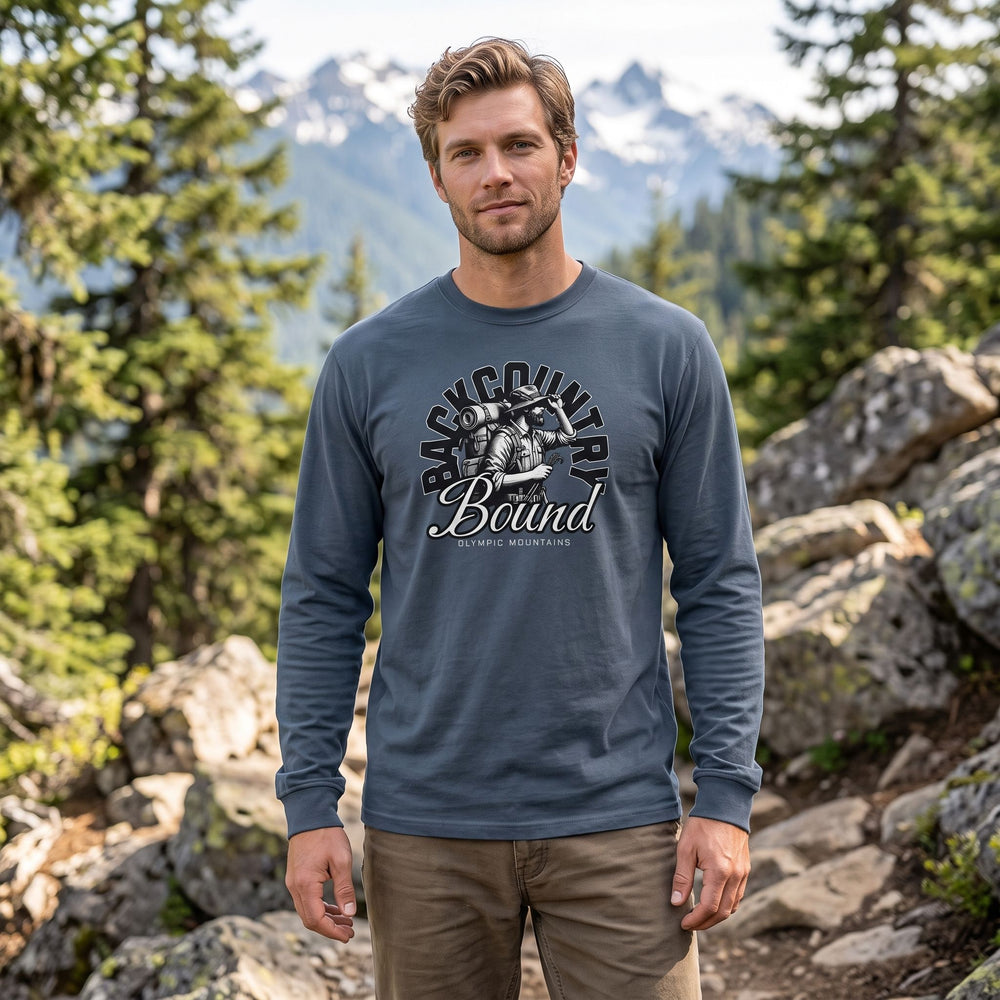 Adult model in outdoor setting with blurred foliage, wearing durable long sleeve shirt themed around Olympic Mountains exploration.