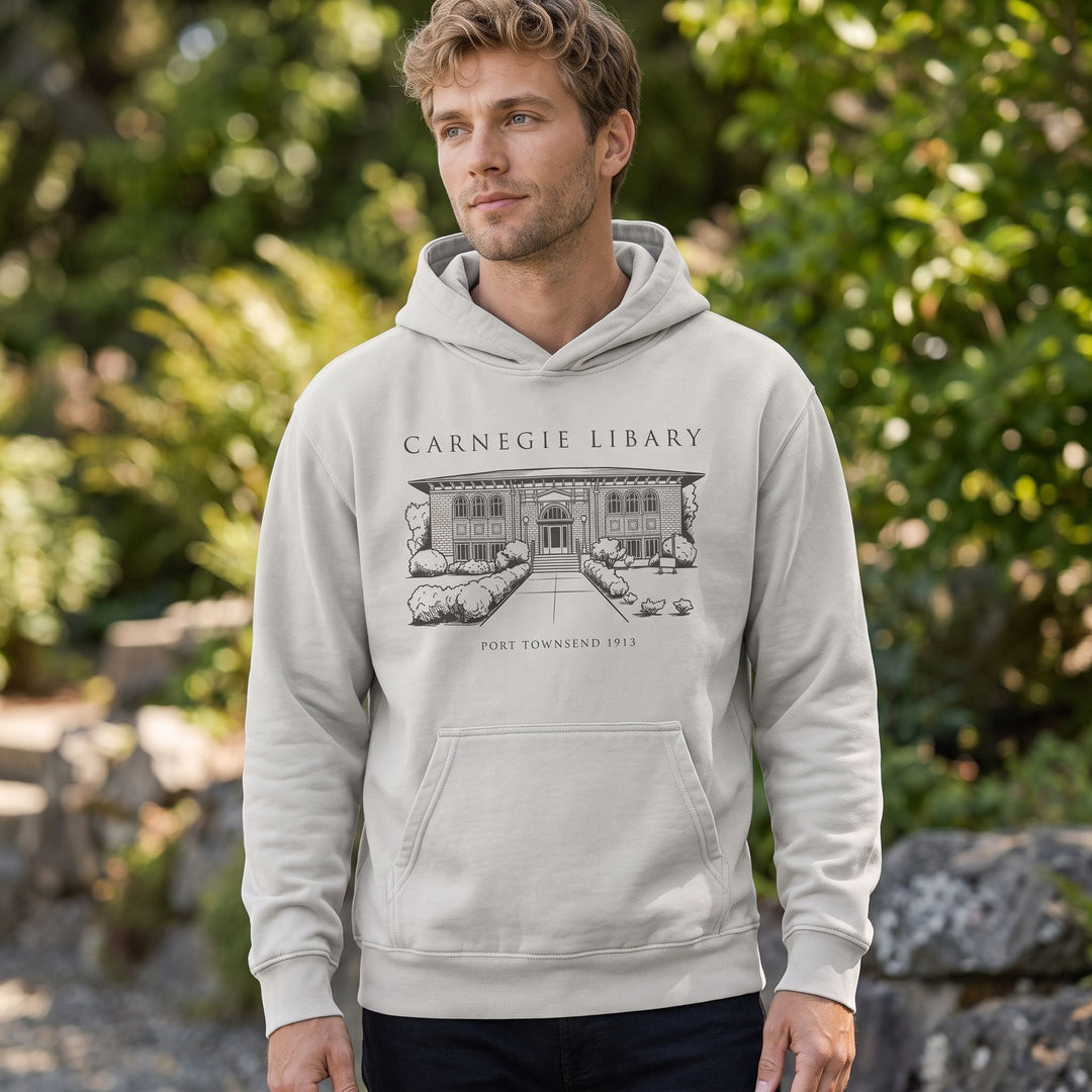 Fashionable hoodie showcasing historic Carnegie Library illustration, worn outdoors with natural background.