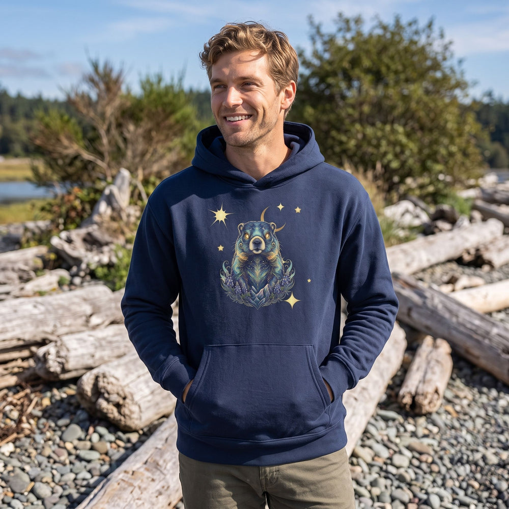 Adult model wearing Aries Olympic Marmot organic fleece hoodie outdoors amid greenery and water, embodying bold, adventurous style