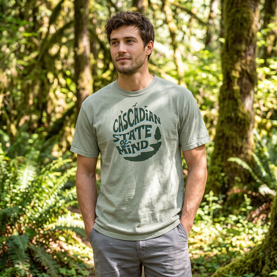Relaxed casual man in outdoor environment with blurred foliage, modeling the rugged heavyweight t-shirt.