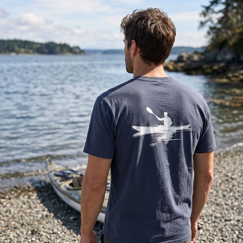 Casual model wearing Strait Passage Pocket Tee outdoors, surrounded by greenery, showcasing the rugged and soft cotton design suitable for outdoor adventures.