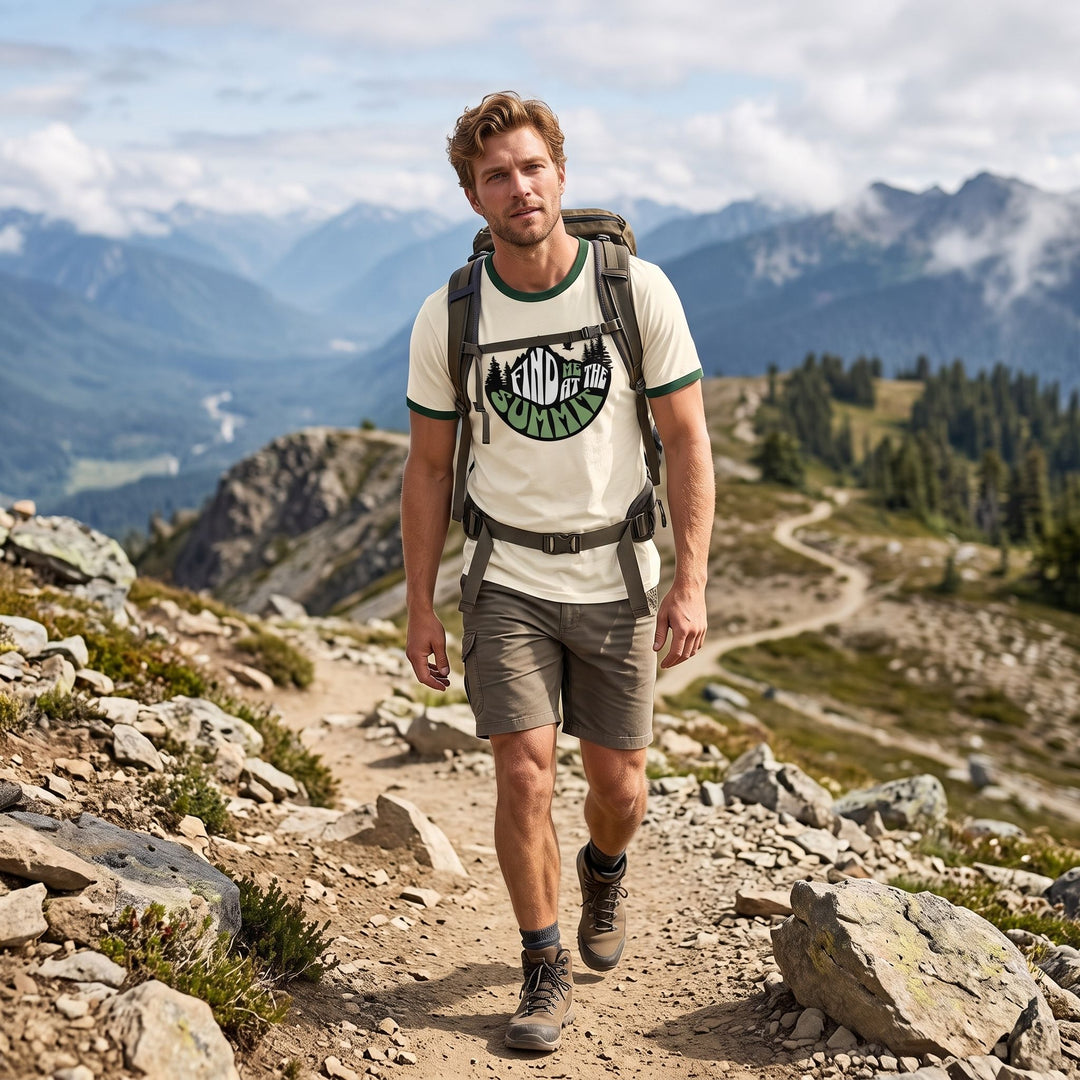 Male model wearing The Summit Signal Ringer Tee in an outdoor setting with greenery and natural daylight, surrounded by blurred foliage and rocks.