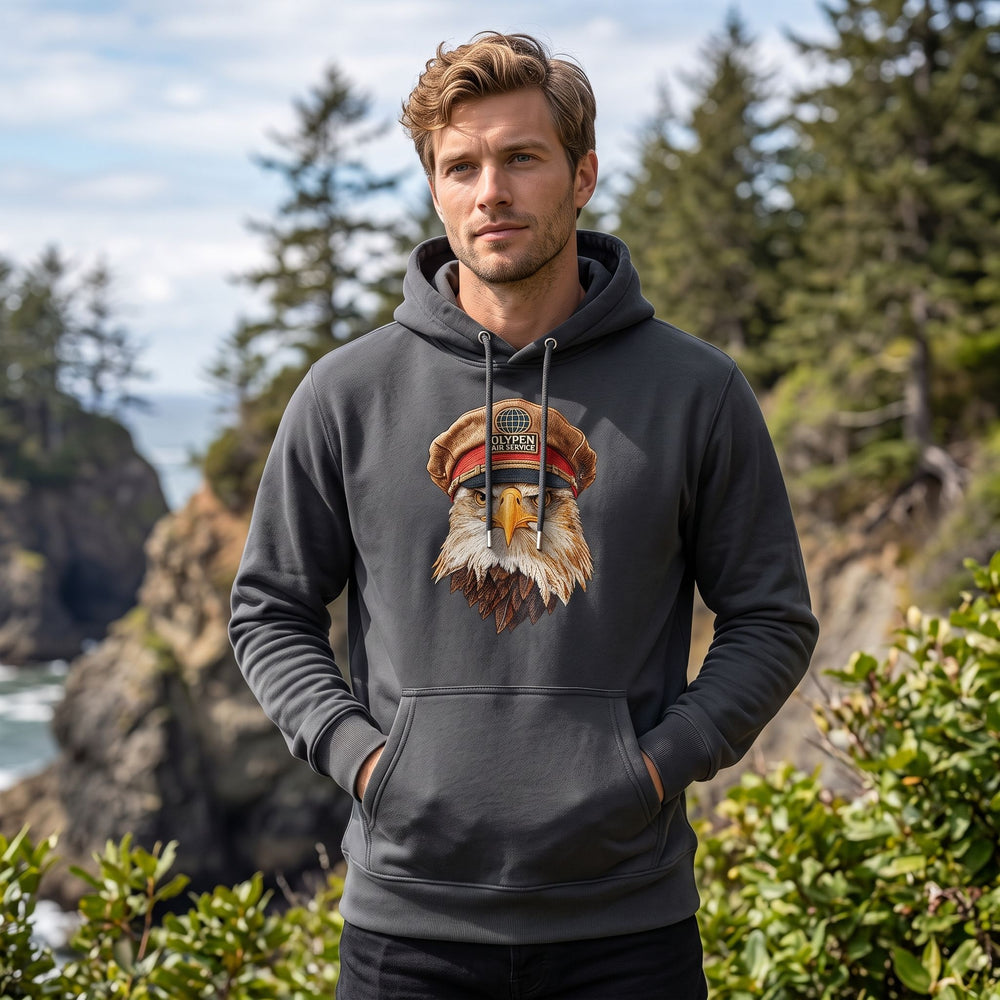 Adult male model wearing The Commander heavyweight hoodie in outdoor nature setting with greenery and daylight
