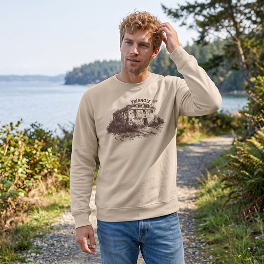 Model outdoors wearing Triangle of Fire Sweatshirt in natural sunlight with blurred foliage background, emphasizing rugged style.