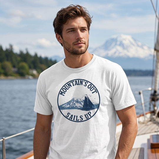 Relaxed man in casual style wearing the sailing-themed T-shirt outdoors near water and foliage.
