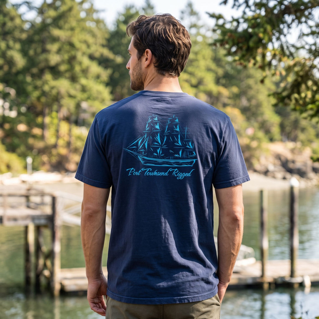 Casual male model wearing Port Townsend rigged heavyweight t-shirt outdoors with greenery background.