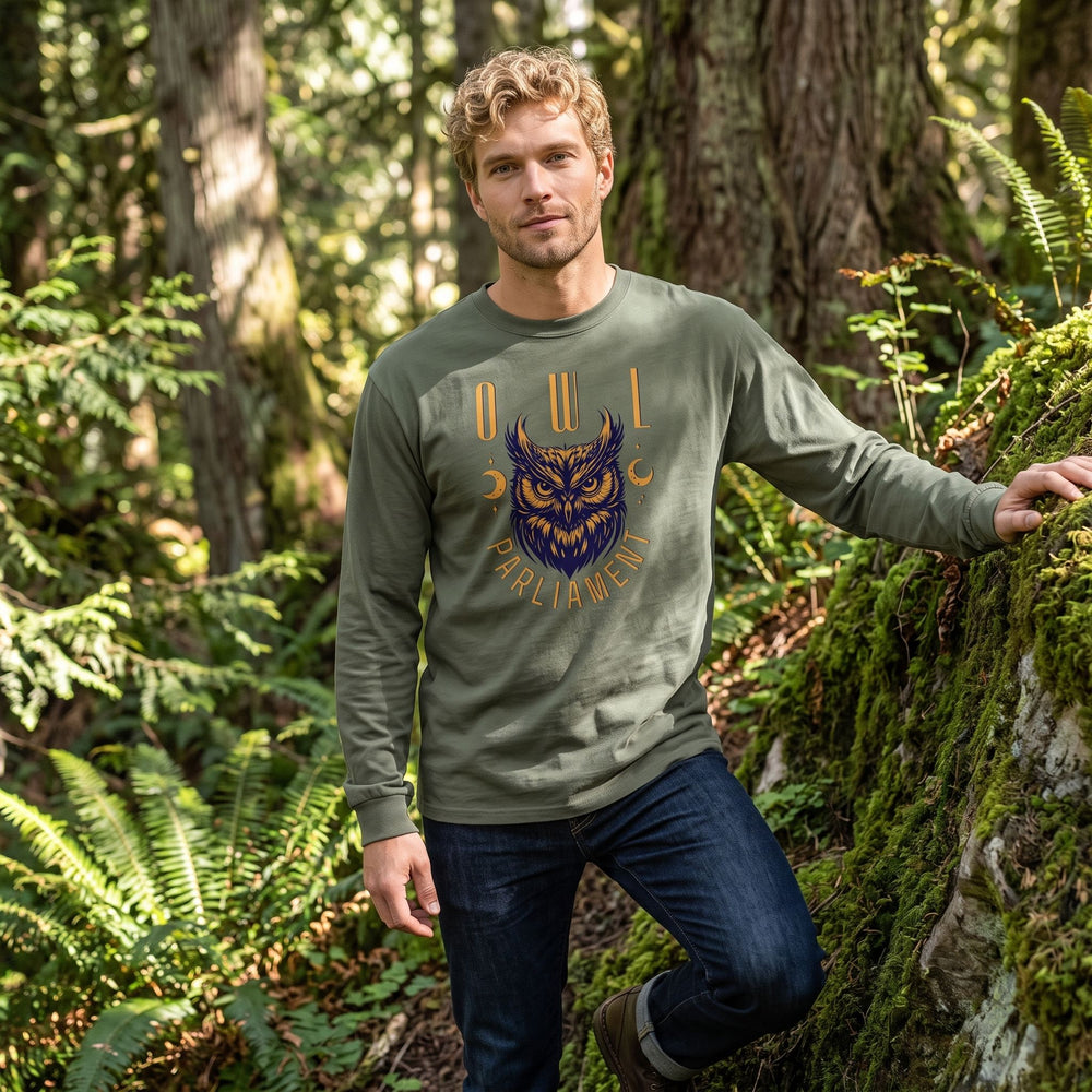 Adult male model wearing green owl design long sleeve shirt outdoors with blurred foliage background.