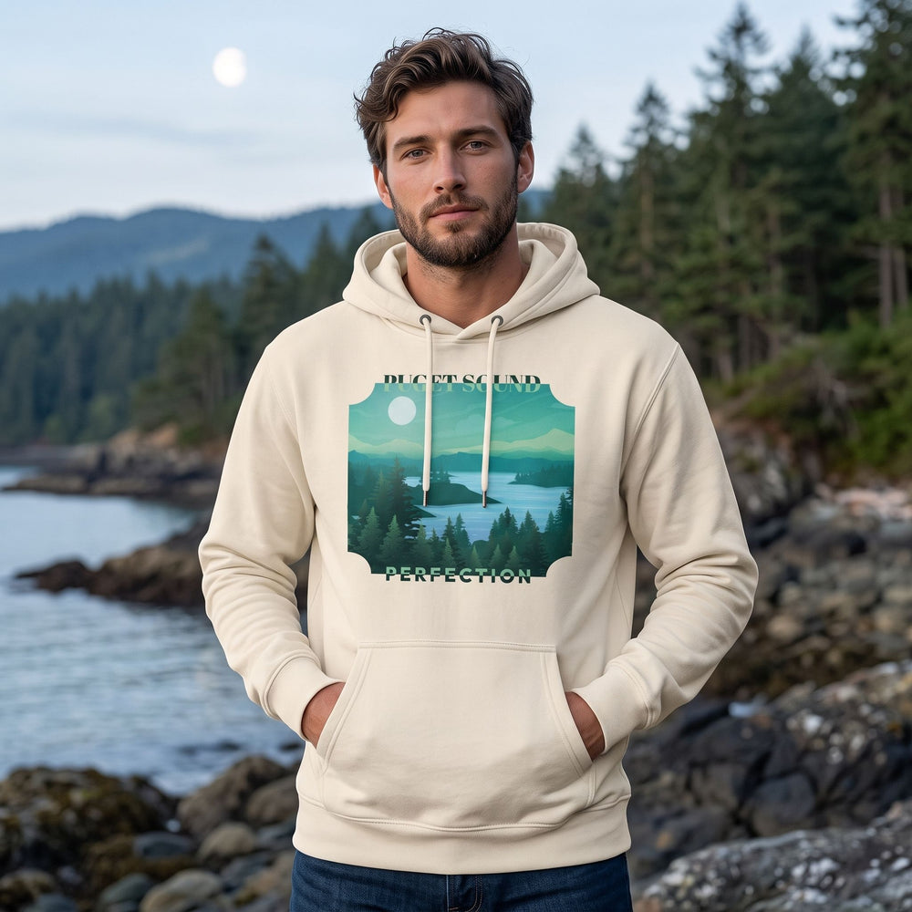Adult model wearing Puget Sound Perfection hoodie in outdoor setting with greenery and water, highlighting its serene Pacific Northwest design.