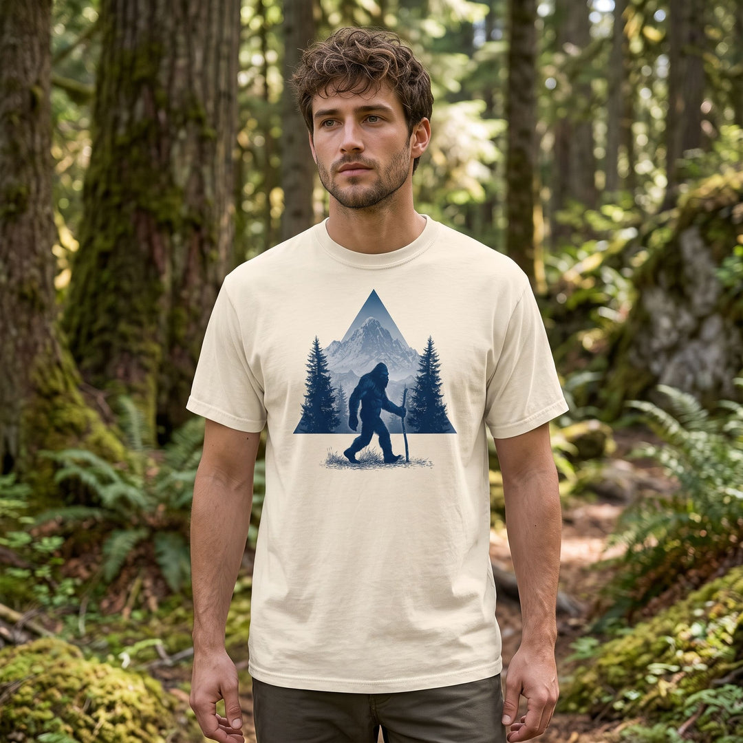 Model showcasing the High Country Wanderer Tee in an outdoor setting with blurred foliage, emphasizing its wilderness graphic and durable fabric.