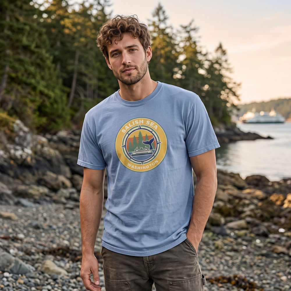 Casual model wearing the Salish Sea compass t-shirt outdoors, surrounded by greenery in natural daylight.