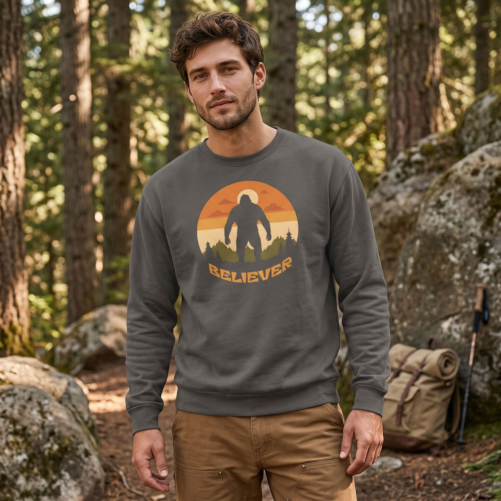 Relaxed Sasquatch Trail Tracker Crewneck on model in outdoor setting with greenery, natural daylight, and blurred foliage in background.