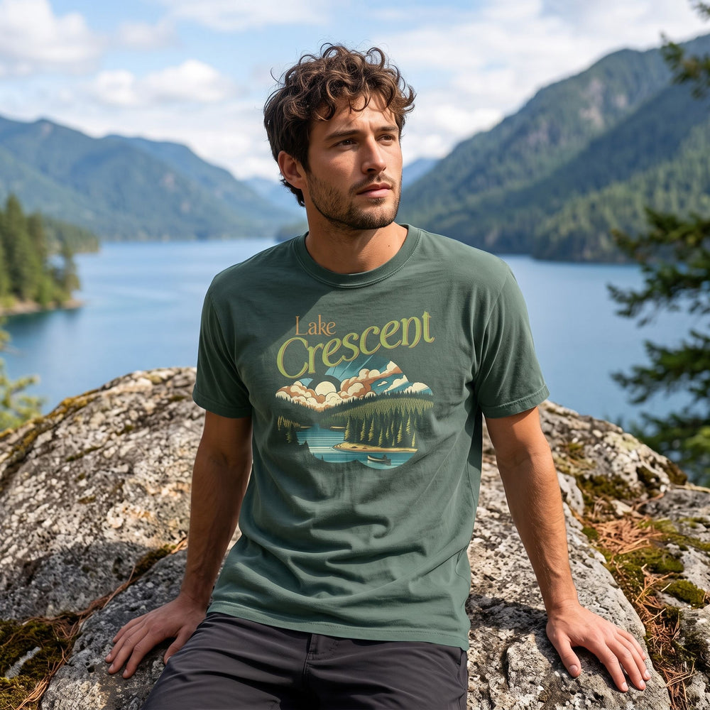 Relaxed model sporting Lake Crescent landscape T-shirt surrounded by blurred trees and outdoor scenery.