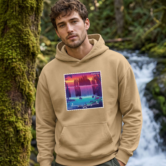 Oversized heavy hoodie featuring a Sol Duc Falls stamp design, modeled outdoors with natural daylight and blurred foliage background.