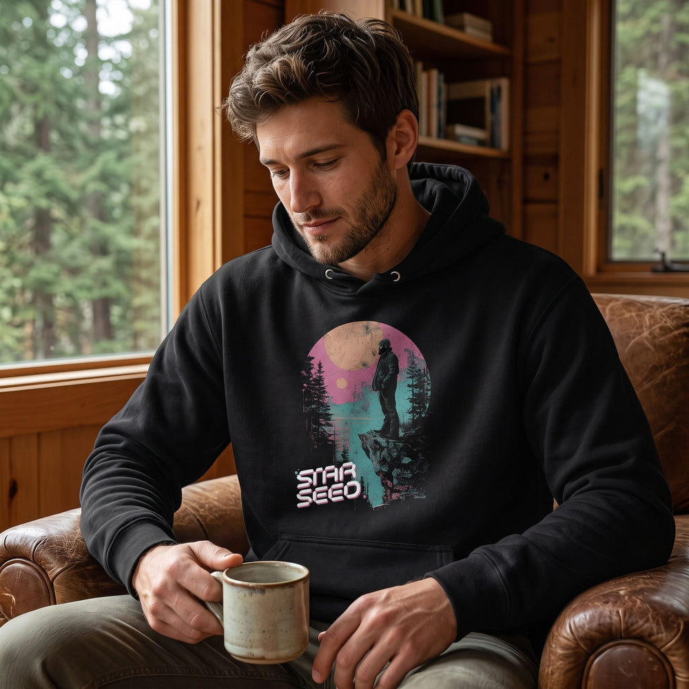 Casual man wearing the colorful Star Seed Hoodie in a cozy living room setting, relaxed and comfortable.