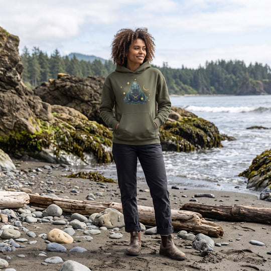 Outdoor scene with Zara modeling the Taurus Northern Elephant Seal Organic Fleece Hoodie in natural daylight, surrounded by greenery and natural elements.
