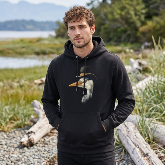 Outdoor lifestyle shot of a relaxed adult wearing The Shoreline Sophisticate hoodie with blurred foliage and water in the background