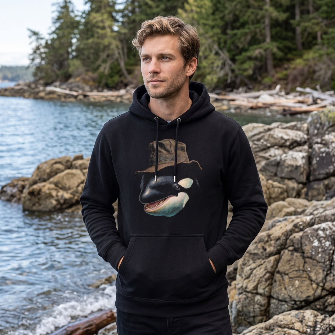 Adult male model in casual style wearing The Sound Strategist hoodie in outdoor nature setting with blurred foliage and water
