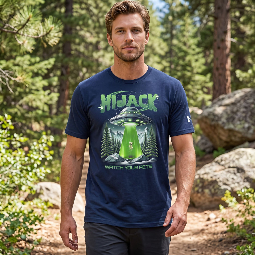 Unisex UFO Hijack Tee with alien and pet design, modeled outdoors with natural sunlight and greenery in background.