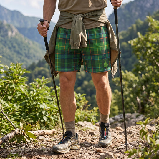 Relaxed adult model wearing Untamed Tartan Mesh Cernunnos Shorts in outdoor setting with greenery, perfect for adventure and casual wear.