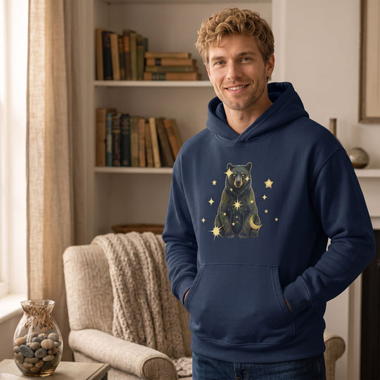 Adult male model wearing Virgo Black Bear fleece hoodie in a comfortable home environment with warm window light.