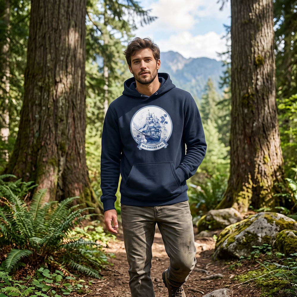 Casual model wearing The Wildward Sail Midweight Hoodie outdoors with greenery and water in the background, capturing a relaxed, natural vibe.